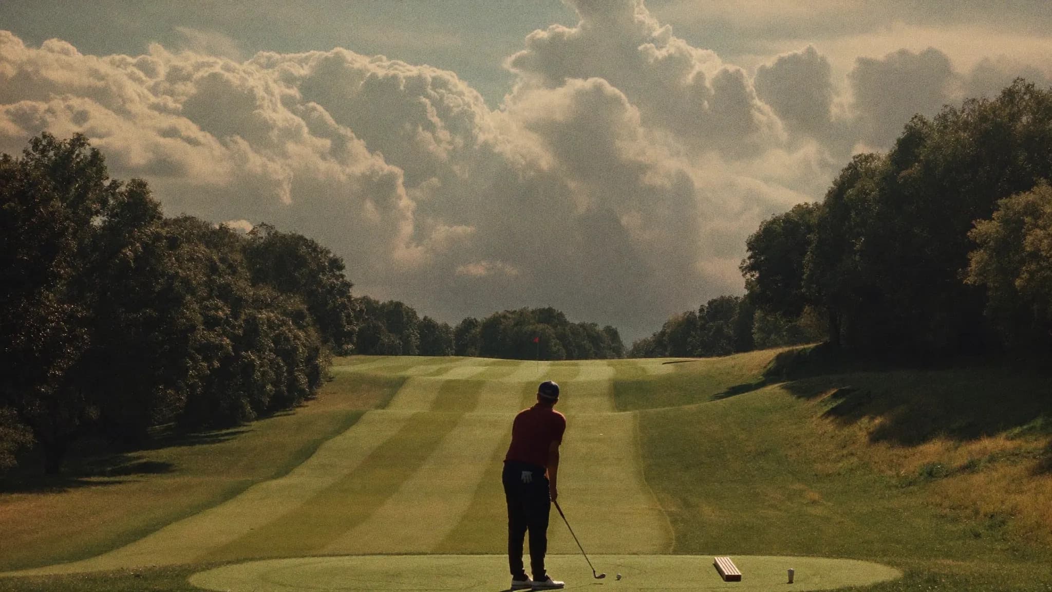 Golfer beim Abschlag auf dem Fairway im goldenen Abendlicht